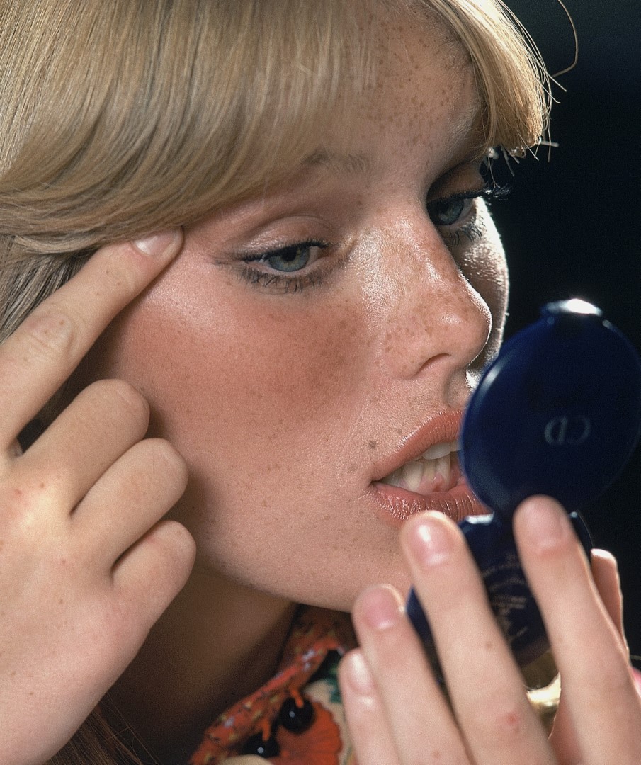 Close up of model holding a compact mirror checking her makeup *** Local Caption ***