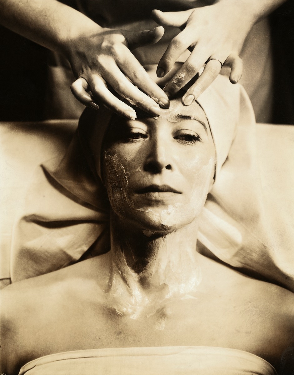Woman receiving facial massage with skin-care product 