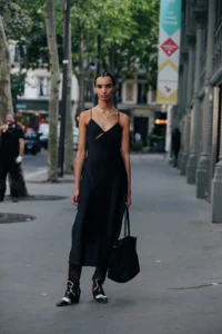 model in black slip dress and boots