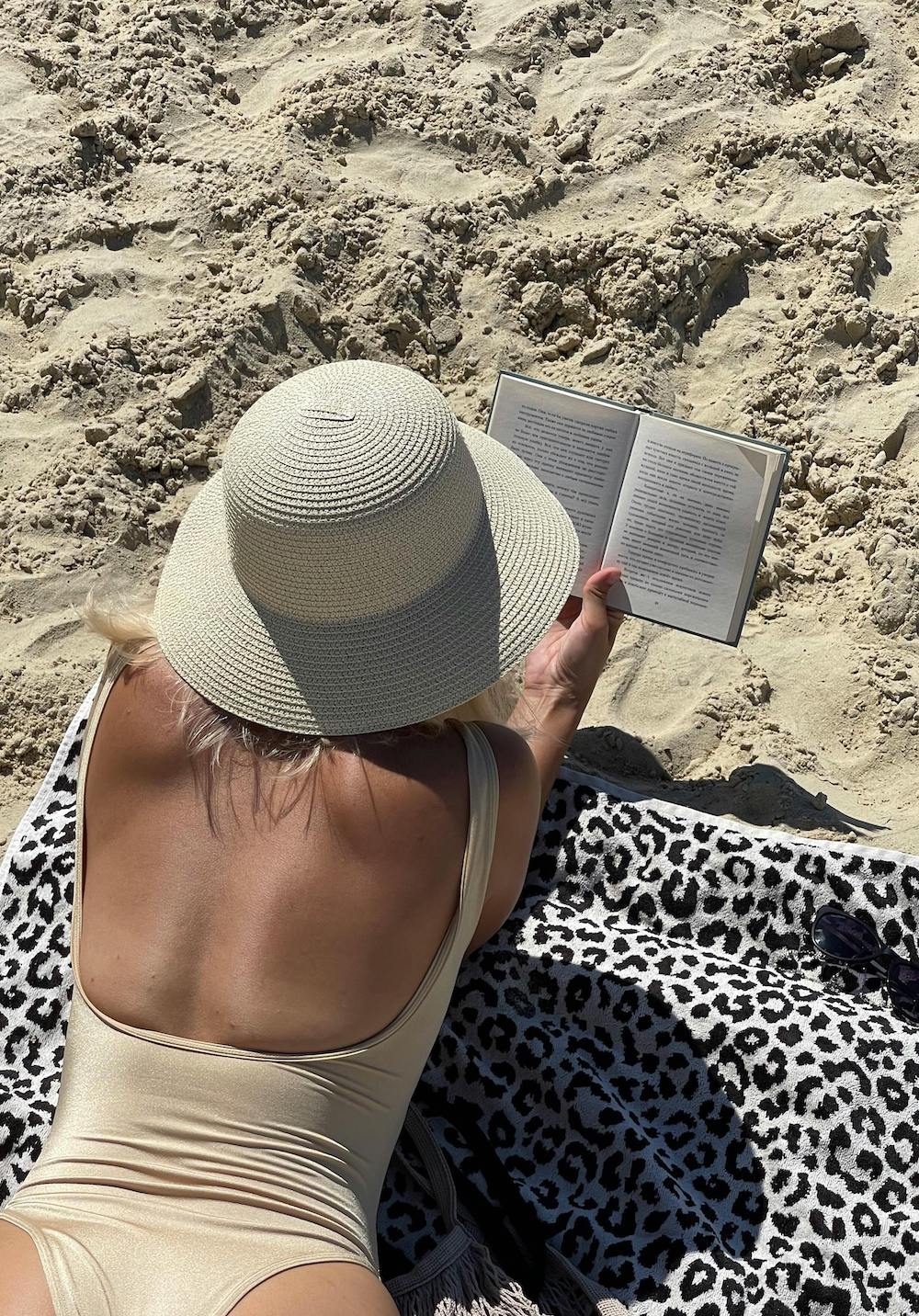 žena se sunča i čita knjigu