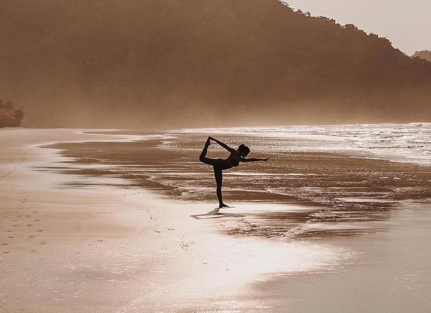 žena vježba jogu na plaži
