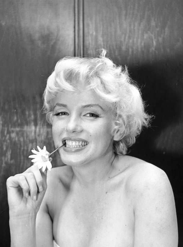 Portrait of actress Marilyn Monroe with the stem of a flower between her teeth, photographed at Cecil Beaton's room at the Ambassador Hotel in New York in February 1956. Marilyn Monroe;