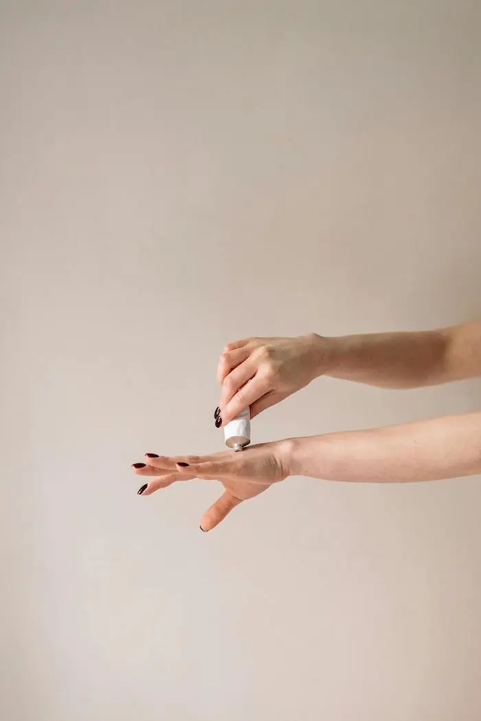 žena maže ruke kremom za ruke