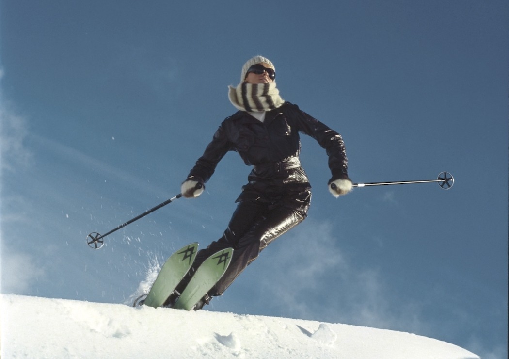 Model skiing at Falls Creek, Australia in a brown vinyl ski suit by Ernst Engel, with black wrap around glasses and Volki skis. Vogue November 01, 1969 Fashion Feature