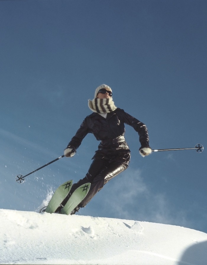 Model skiing at Falls Creek, Australia in a brown vinyl ski suit by Ernst Engel, with black wrap around glasses and Volki skis.