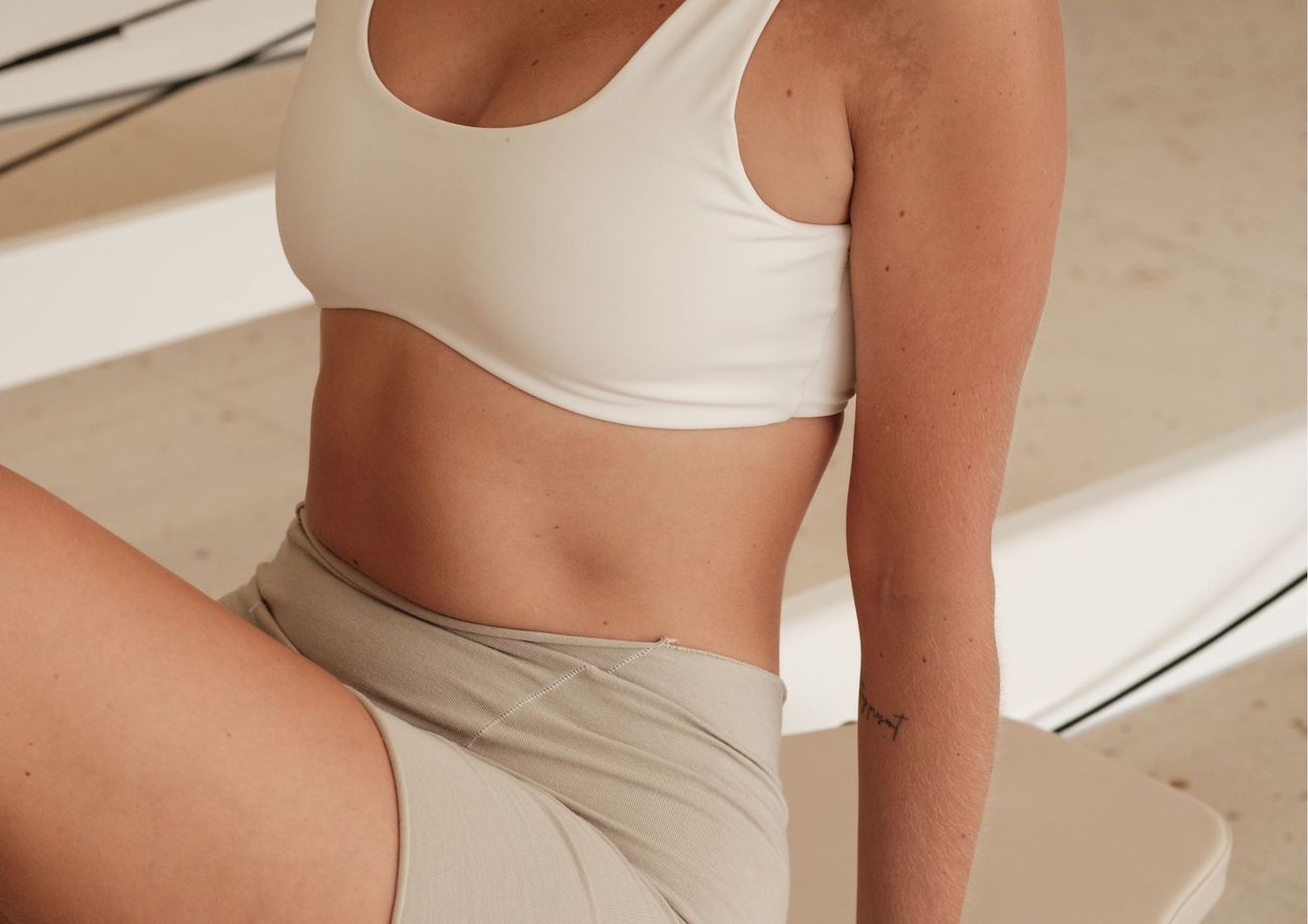 žena vježba pilates u bež outfitu