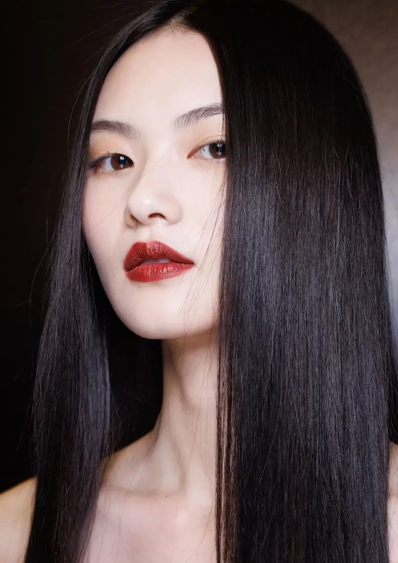 model s dugom sjajnom kosom u backstageu Versace 2025 revije