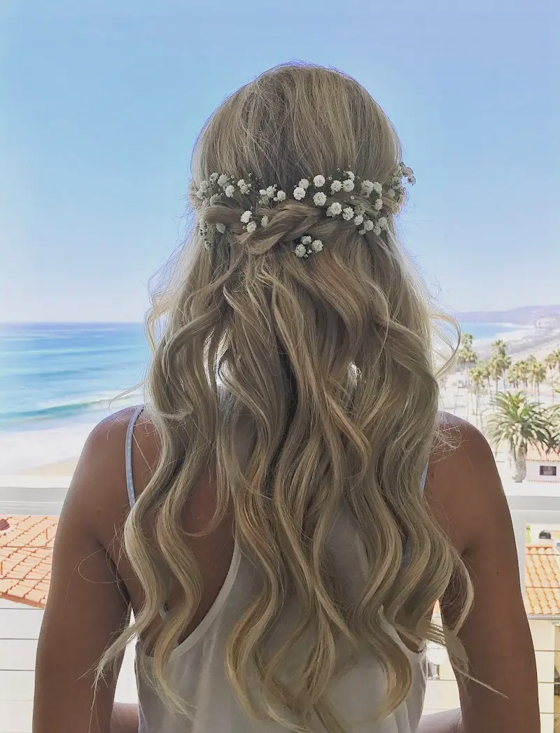 Dekle z dolgimi blond lasmi, zvitimi v napol dvignjeno pričesko, gleda v morje