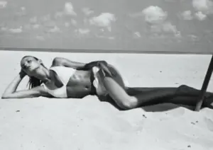 žena s jakim trbušnjacima leži na pješčanoj plaži