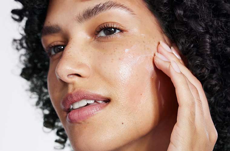 žena s tamnim mrljicama nanosi serum protiv hiperpigmentacija