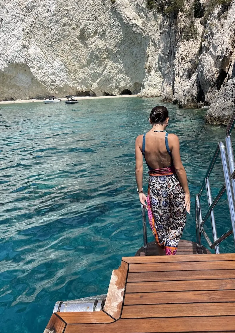 Dekle s črnimi lasmi, spetimi v figo, vstopa v morje