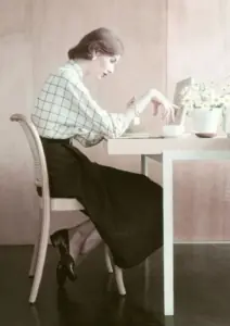 žena sjedi za stolom s doručkom i tužno gleda u hranu