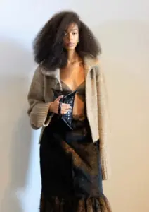 model s kovčravom kosom i bež jaknom