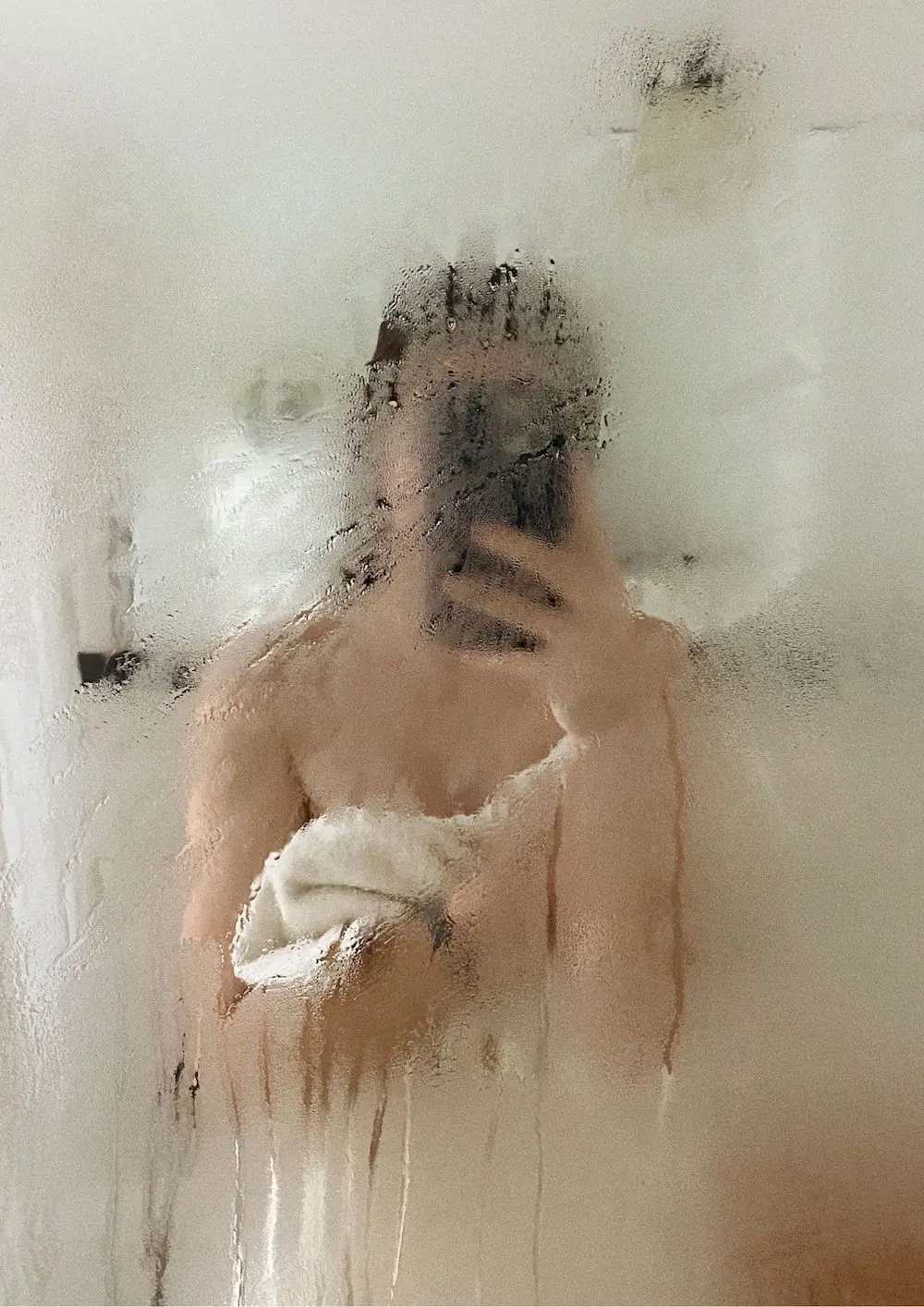 žena u kupaonici sa zamagljenim staklom