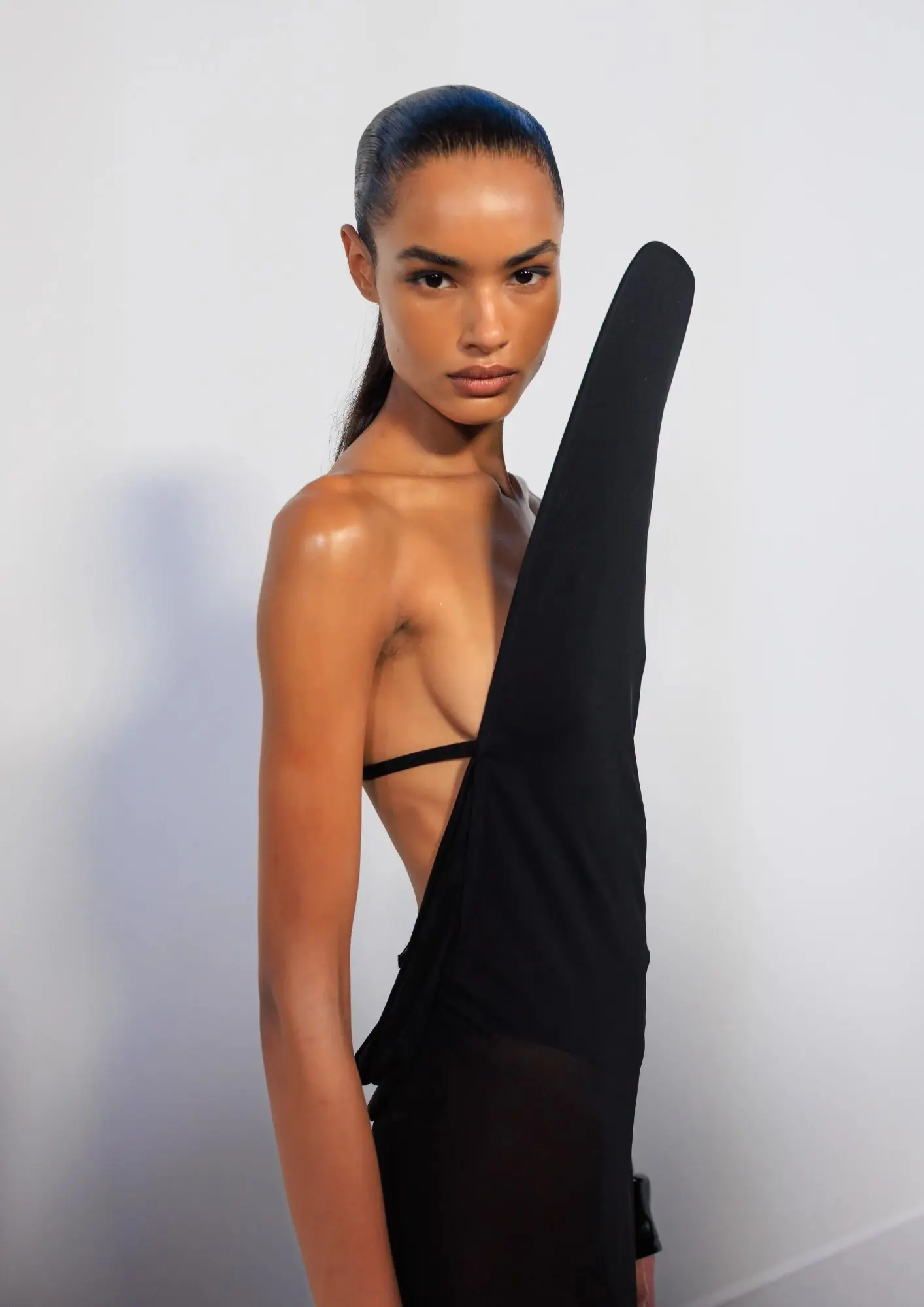 model sa sjajnom kožom i ujednačenim tenom u crnoj haljini