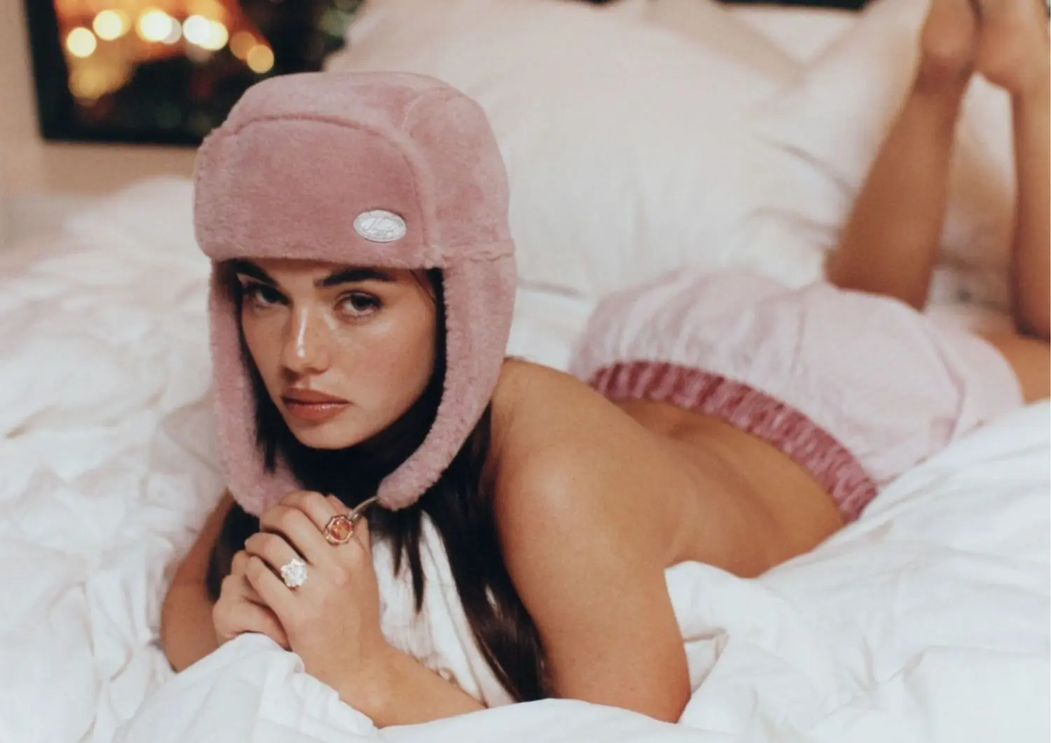 djevojka leži u krevetu s rozom kapom na glavi