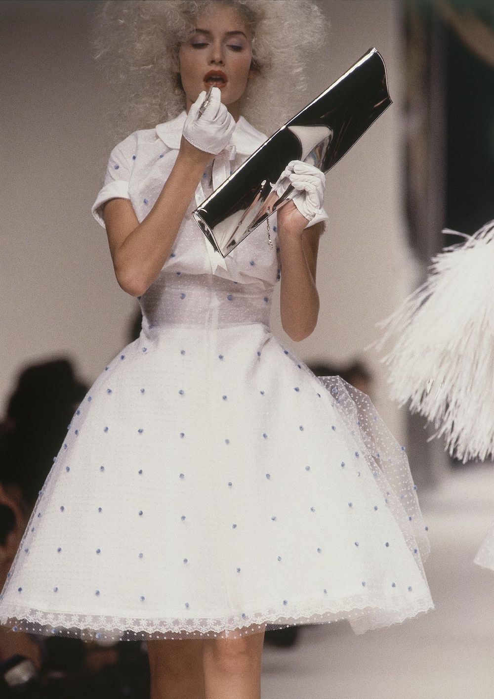 žena nanosi balzam na usne u bijeloj haljini