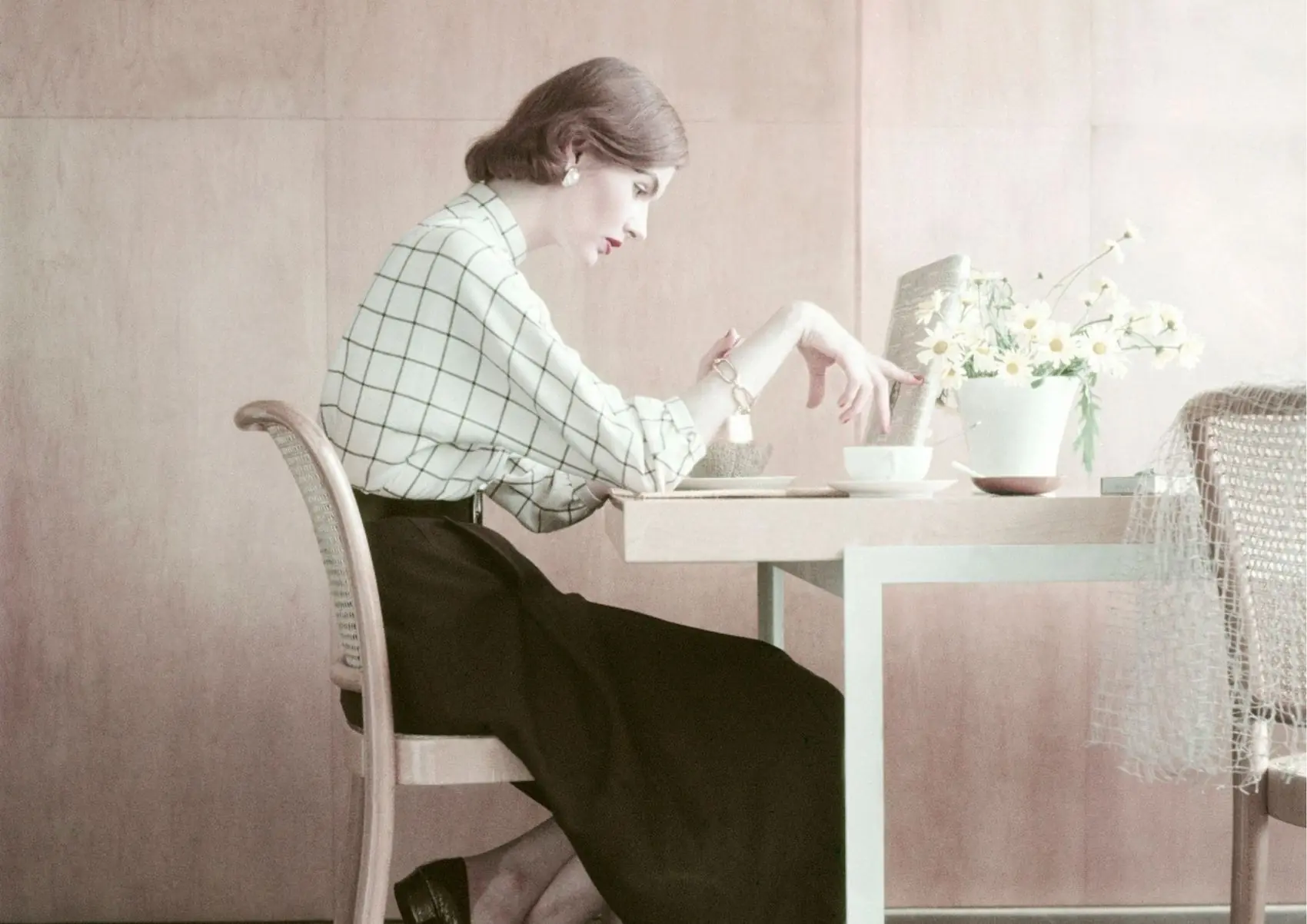 žena u bijeloj košulju i crnoj suknji sjedi za stolom pod stresom