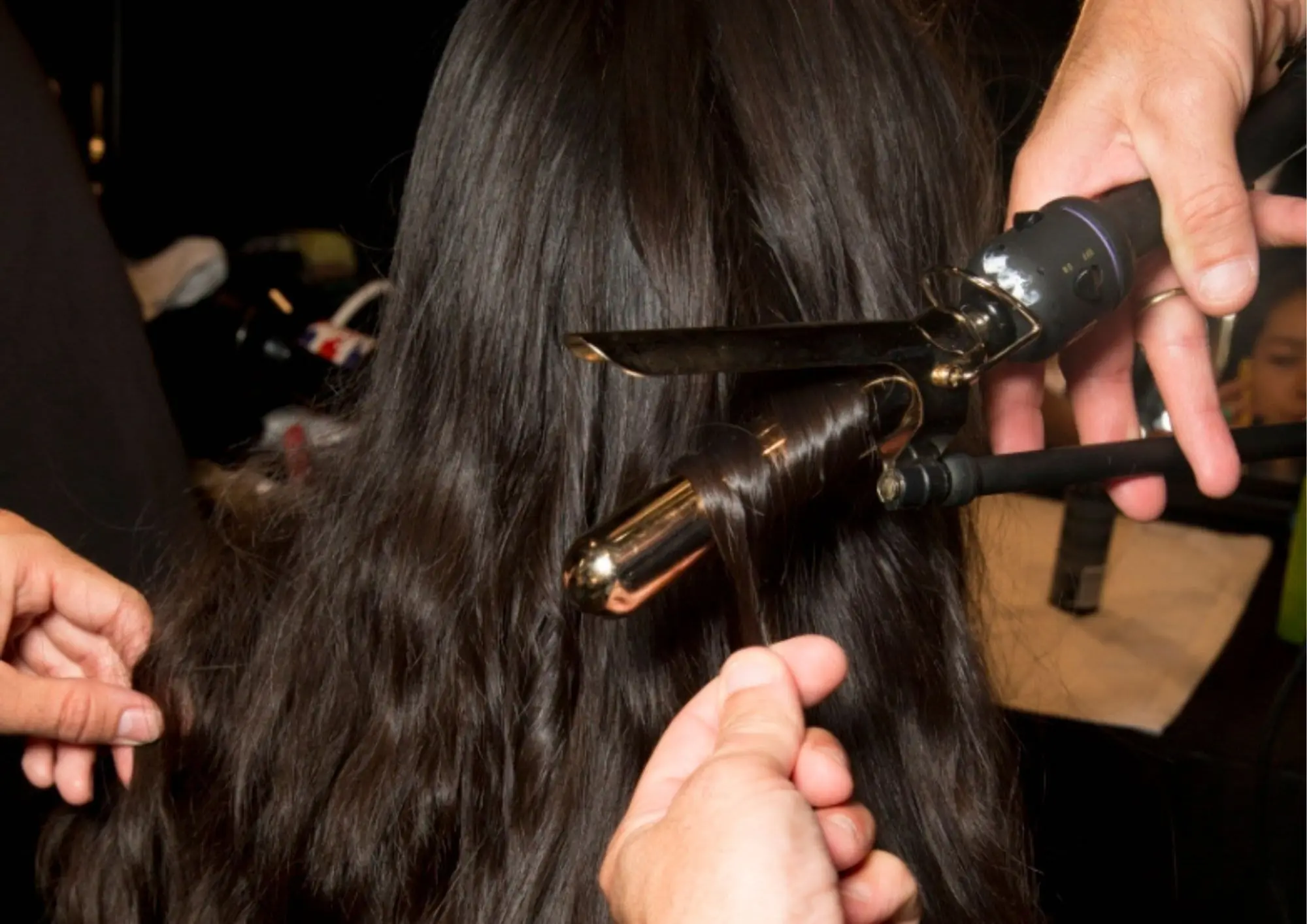 frizer oblikuje kosu modela s uvijačem na reviji